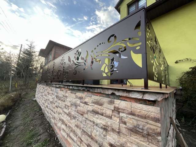 Detal balustrady balkonowej z ażurowym wzorem roślinnym wyciętym CNC