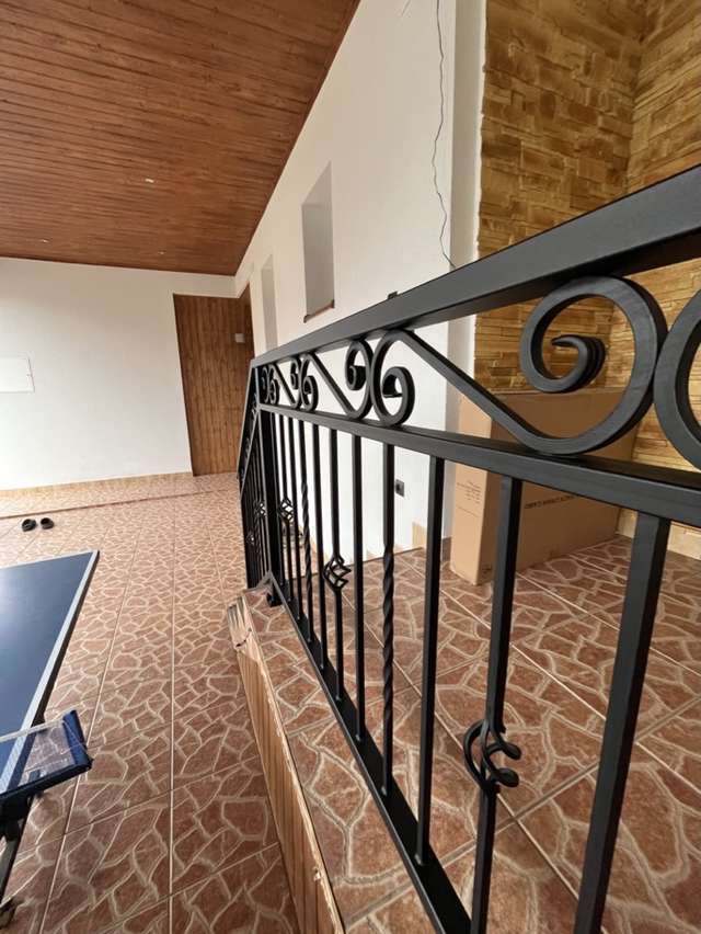 Detal czarnej balustrady kutej z wygiętymi elementami dekoracyjnymi