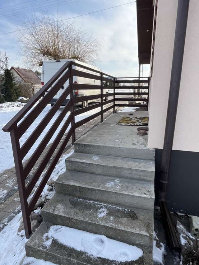 Brązowa balustrada metalowa przy zewnętrznych schodach do domu