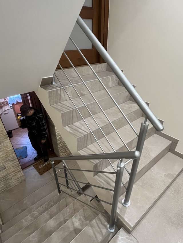 Metalowa balustrada schodowa widziana z górnego spocznika