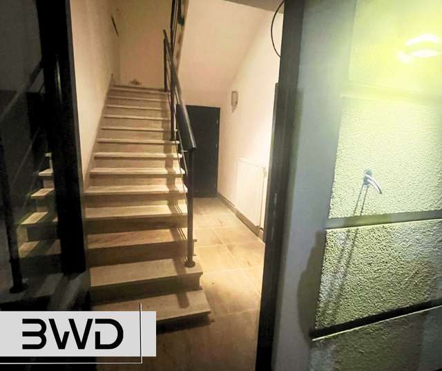 Minimalistyczna balustrada stalowa przy schodach w jasnym wnętrzu