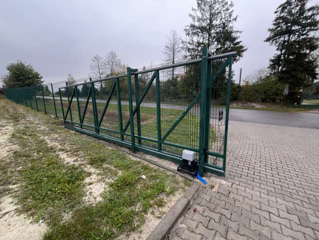 Stalowy stelaż bramy przesuwnej z siatką i zamontowanym napędem