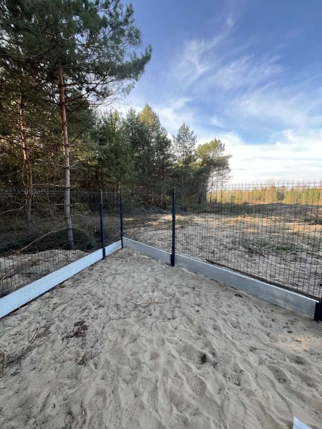 Narożny słupek ogrodzenia panelowego osadzony na betonowej podmurówce